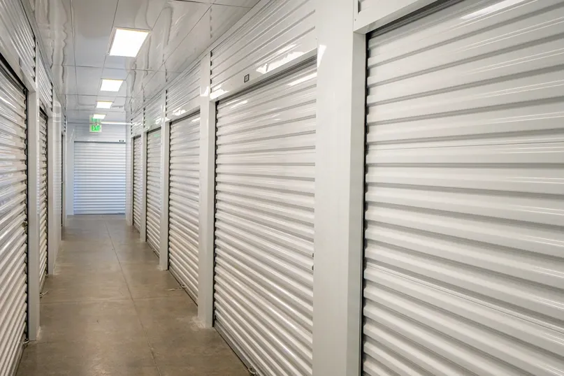 Indoor climate controlled storage hallway with white roll-up unit doors